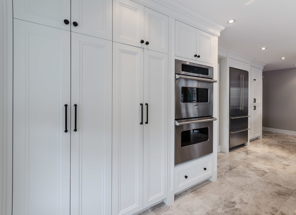 Design ideas for a medium sized vintage galley kitchen pantry in Toronto with recessed-panel cabinets, white cabinets, granite worktops, stainless steel appliances, travertine flooring and an island.