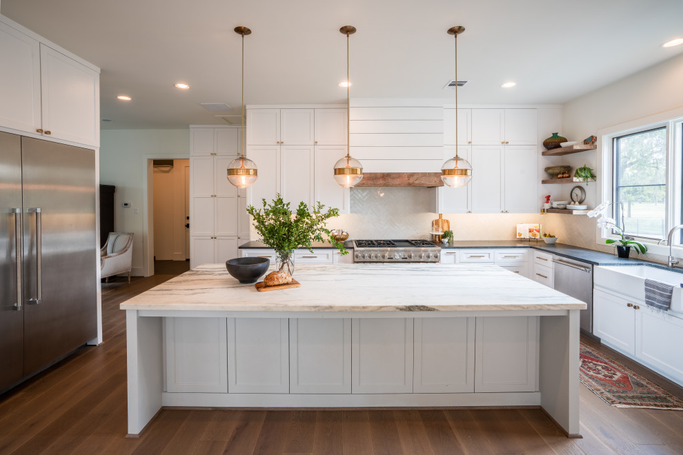 Exempel på ett mycket stort klassiskt grå grått kök, med en rustik diskho, skåp i shakerstil, vita skåp, marmorbänkskiva, vitt stänkskydd, stänkskydd i tunnelbanekakel, rostfria vitvaror, mellanmörkt trägolv, en köksö och brunt golv