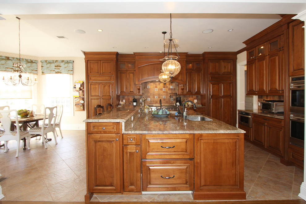 Idéer för att renovera ett stort vintage beige beige kök, med en undermonterad diskho, luckor med upphöjd panel, skåp i mellenmörkt trä, granitbänkskiva, orange stänkskydd, stänkskydd i keramik, rostfria vitvaror, travertin golv, en köksö och beiget golv