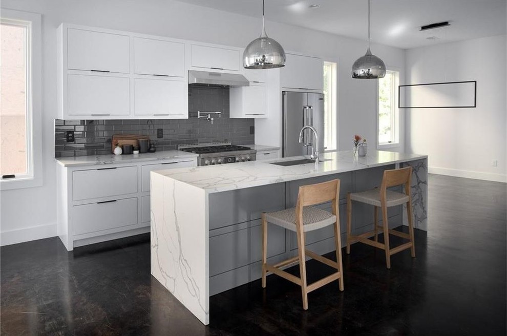 Foto di una cucina moderna di medie dimensioni con lavello sottopiano, ante con bugna sagomata, ante bianche, top in marmo, pavimento con piastrelle in ceramica, 2 o più isole, pavimento nero e top bianco
