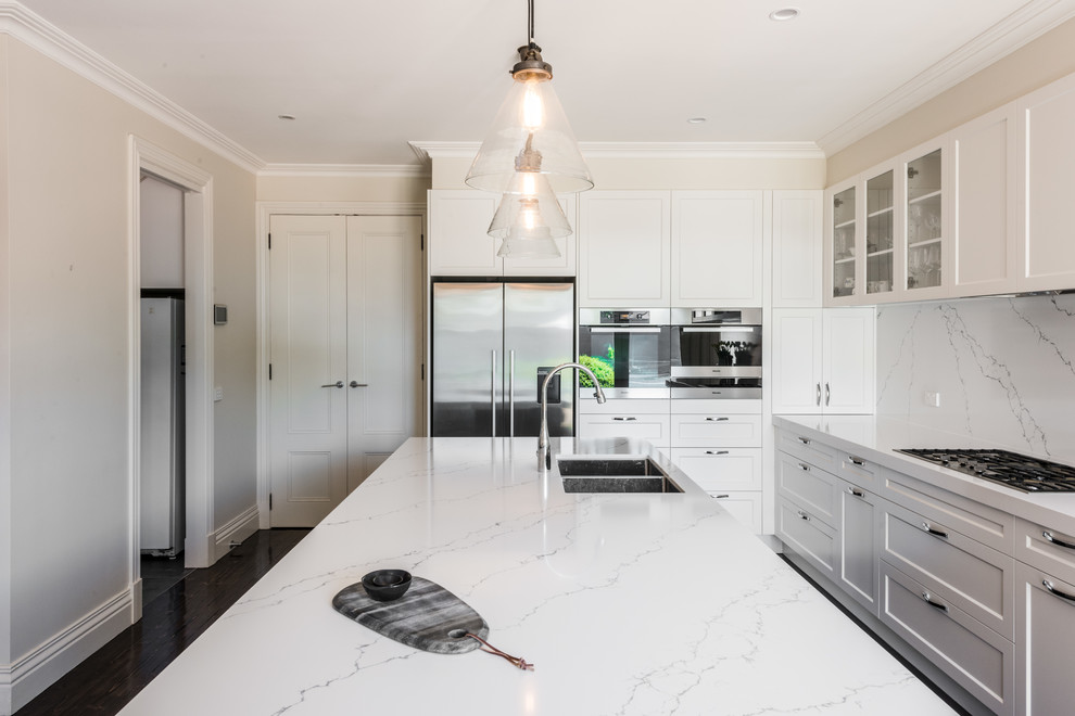 Example of a mid-sized trendy l-shaped dark wood floor eat-in kitchen design in Melbourne with a drop-in sink, shaker cabinets, white cabinets, marble countertops, white backsplash, marble backsplash, stainless steel appliances and an island