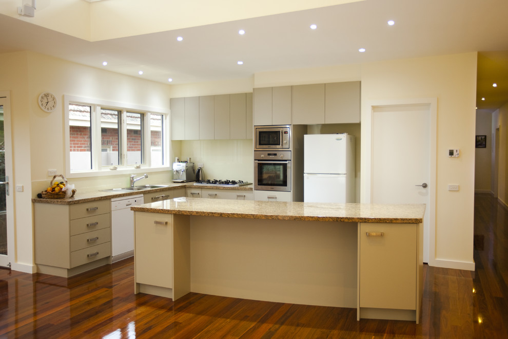 Large trendy medium tone wood floor kitchen photo in Melbourne with a double-bowl sink, beige cabinets, marble countertops, beige backsplash, stainless steel appliances and an island