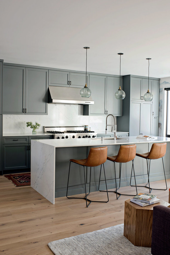 Foto di una cucina classica con lavello sottopiano, ante in stile shaker, ante verdi, elettrodomestici in acciaio inossidabile, parquet chiaro e top bianco