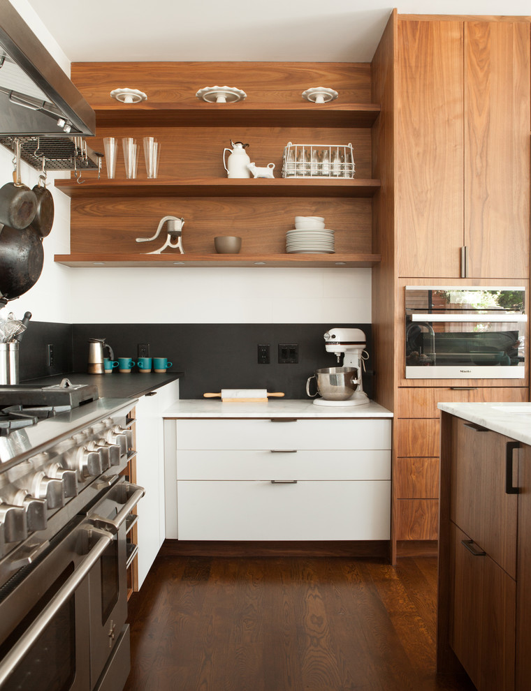 Immagine di una grande cucina contemporanea con ante lisce, ante in legno scuro, top in marmo, paraspruzzi nero, elettrodomestici in acciaio inossidabile e parquet scuro
