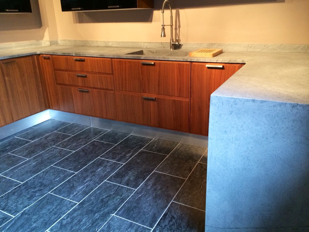 This is an example of a contemporary kitchen in Other with an integrated sink, soapstone worktops and stone slab splashback.