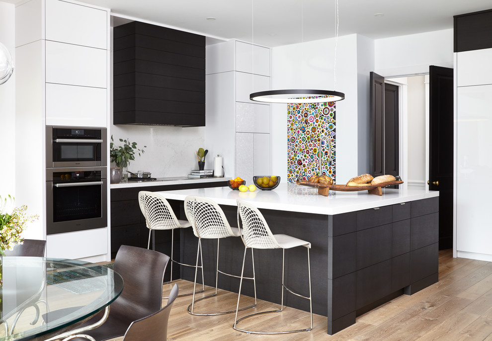 Immagine di una cucina minimalista di medie dimensioni con ante lisce, paraspruzzi bianco, elettrodomestici in acciaio inossidabile, parquet chiaro, top in quarzo composito, pavimento beige e top bianco