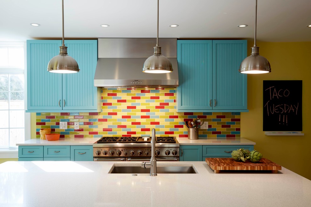 Стильный дизайн: кухня в стиле фьюжн с врезной мойкой, синими фасадами, разноцветным фартуком, фартуком из керамической плитки, техникой из нержавеющей стали, паркетным полом среднего тона и островом - последний тренд