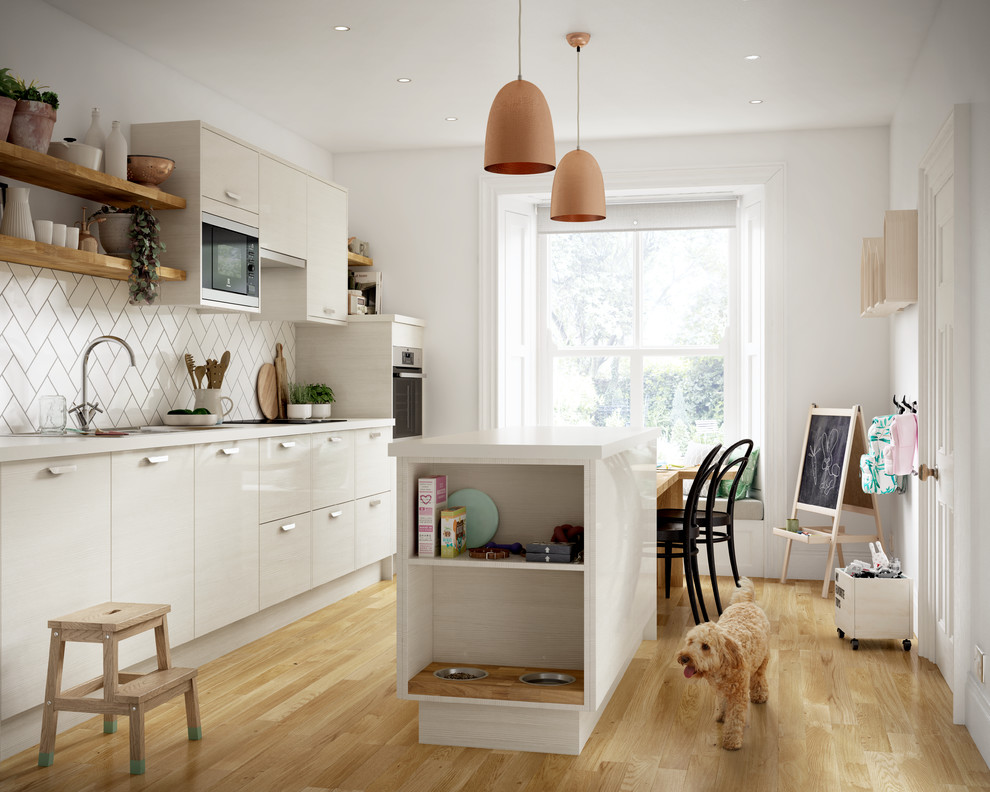 Photo of a contemporary single-wall enclosed kitchen in Other with flat-panel cabinets, white cabinets, white splashback, metro tiled splashback, light hardwood flooring, an island, brown floors, a single-bowl sink and integrated appliances.