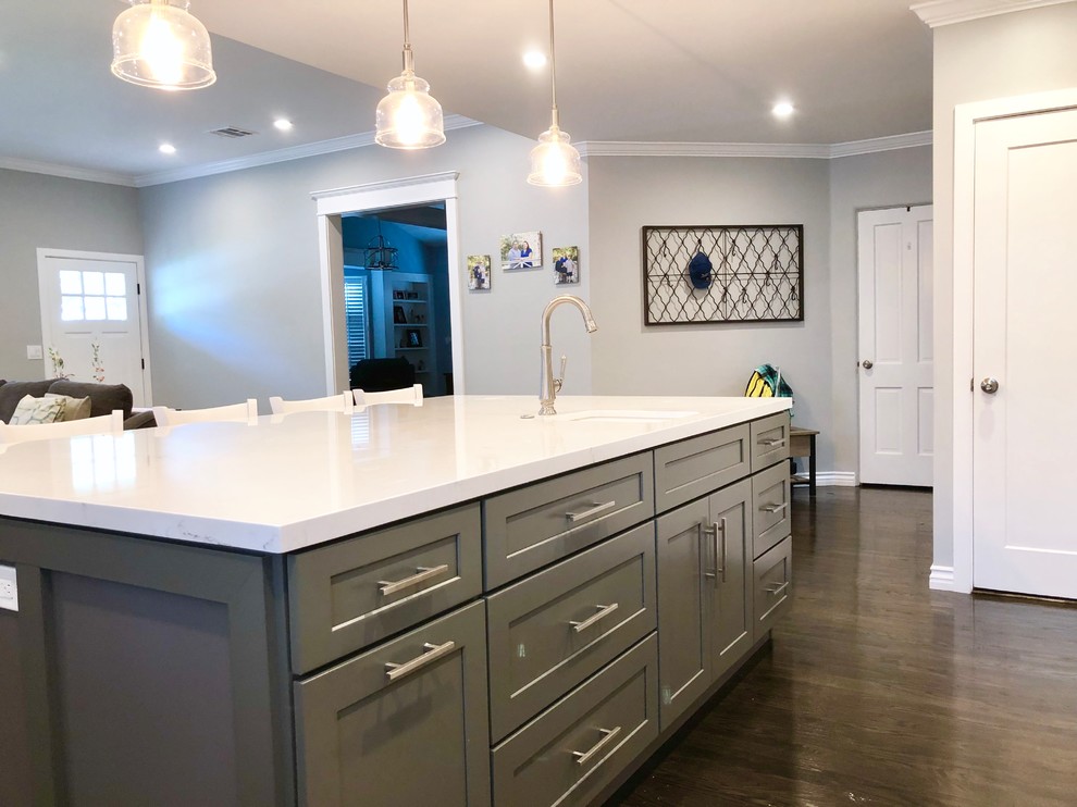 Medium sized classic l-shaped kitchen/diner in Los Angeles with a built-in sink, recessed-panel cabinets, grey cabinets, engineered stone countertops, white splashback, ceramic splashback, stainless steel appliances, dark hardwood flooring, an island, brown floors and white worktops.