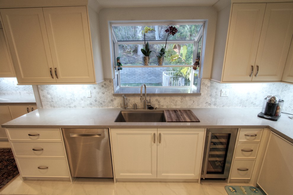 Idéer för att renovera ett mellanstort funkis l-kök, med en undermonterad diskho, luckor med profilerade fronter, vita skåp, bänkskiva i kvarts, grått stänkskydd, stänkskydd i marmor, rostfria vitvaror, marmorgolv, en köksö och vitt golv
