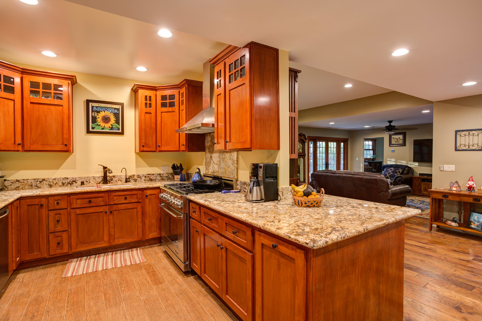 Aménagement d'une cuisine craftsman en U et bois brun fermée avec un évier 2 bacs, un placard à porte shaker, un plan de travail en granite, un électroménager en acier inoxydable, parquet clair, une crédence multicolore, une crédence en dalle de pierre et aucun îlot.