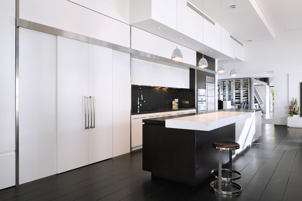 Offene, Einzeilige Moderne Küche mit flächenbündigen Schrankfronten, weißen Schränken, Küchenrückwand in Schwarz, Küchengeräten aus Edelstahl, gebeiztem Holzboden und Kücheninsel in Sydney