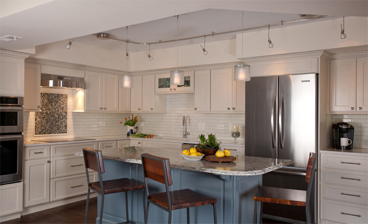 Example of a mid-sized transitional l-shaped dark wood floor eat-in kitchen design in Chicago with an undermount sink, recessed-panel cabinets, white cabinets, quartz countertops, white backsplash, subway tile backsplash, stainless steel appliances and an island