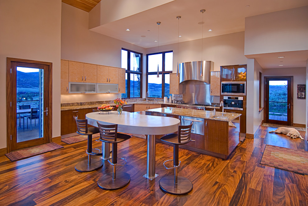Design ideas for a large contemporary l-shaped kitchen/diner in Salt Lake City with a submerged sink, flat-panel cabinets, light wood cabinets, granite worktops, white splashback, stainless steel appliances, medium hardwood flooring, an island and brown floors.