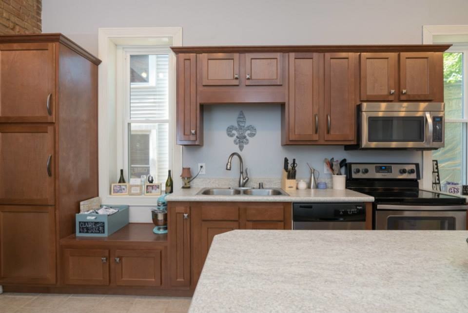 ルイビルにある低価格のコンテンポラリースタイルのおしゃれなアイランドキッチン (シェーカースタイル扉のキャビネット、濃色木目調キャビネット) の写真