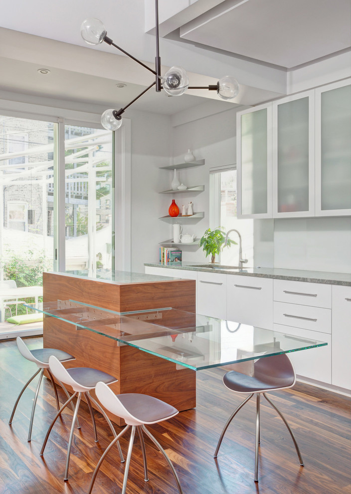 Immagine di una cucina minimal con ante lisce, ante bianche e pavimento in legno massello medio