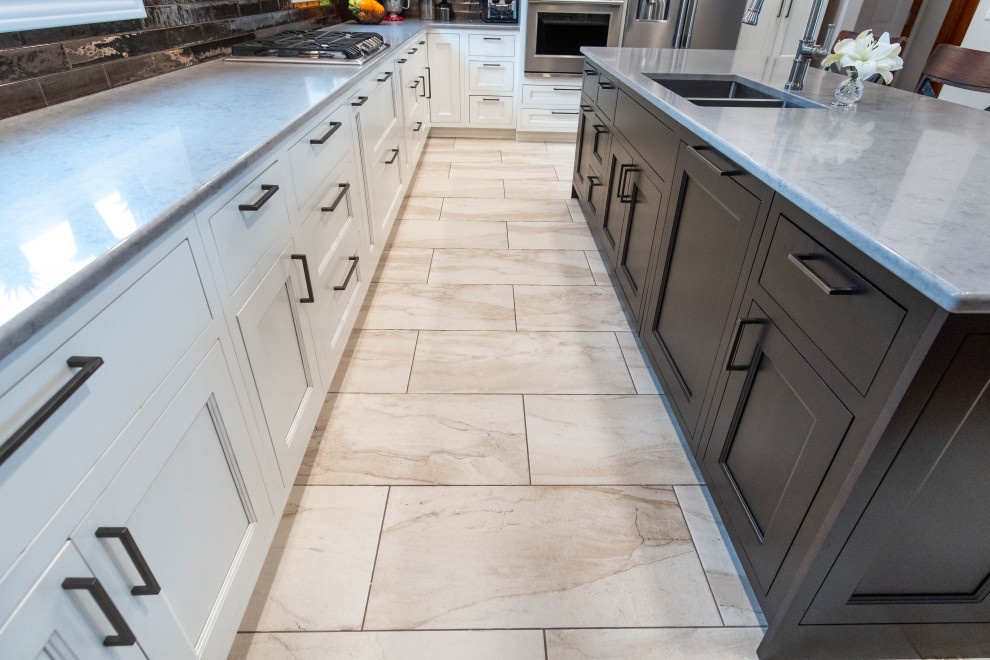 This is an example of a large traditional l-shaped kitchen/diner in Other with a submerged sink, flat-panel cabinets, white cabinets, engineered stone countertops, brown splashback, metal splashback, stainless steel appliances, porcelain flooring, an island, white floors and grey worktops.