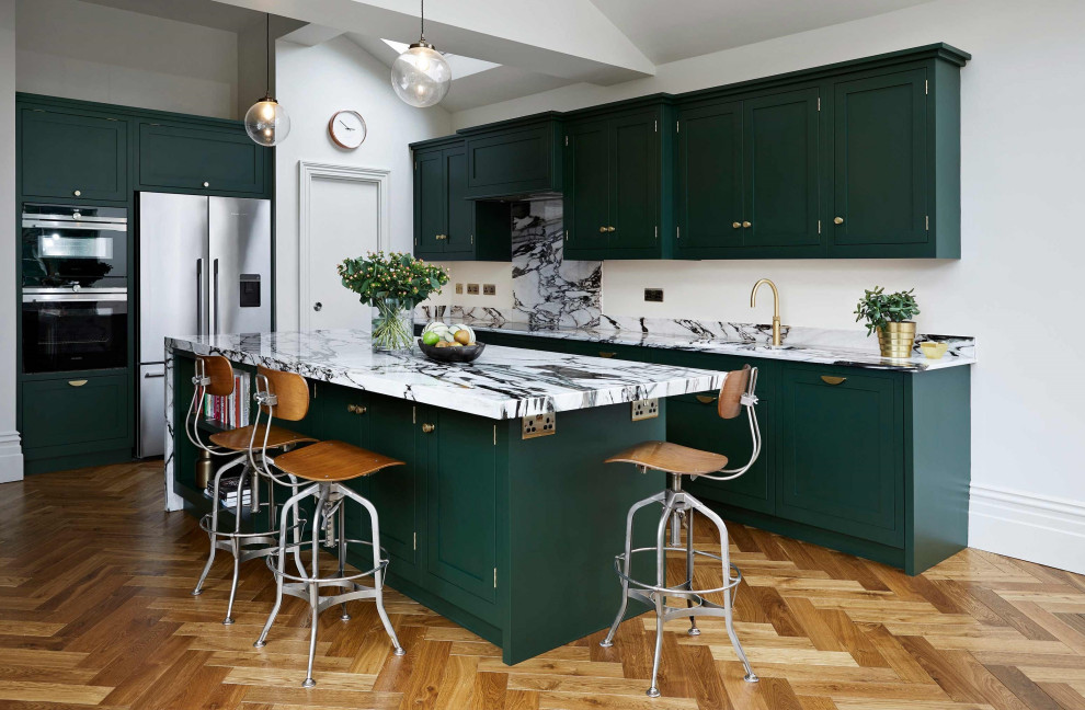 Пример оригинального дизайна: кухня среднего размера в стиле неоклассика (современная классика) с обеденным столом, фасадами в стиле шейкер, зелеными фасадами, столешницей из кварцита, островом и разноцветной столешницей