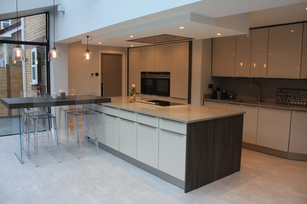 This is an example of a modern single-wall kitchen/diner in Other with flat-panel cabinets, beige cabinets, quartz worktops, beige splashback, stainless steel appliances and multiple islands.
