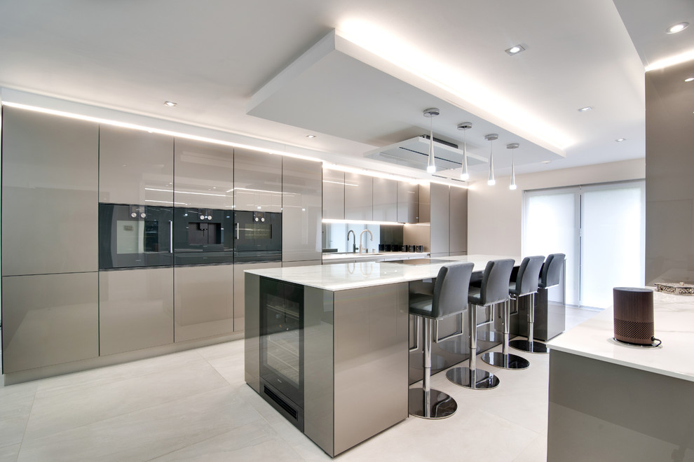 Design ideas for a contemporary kitchen in London with a submerged sink, flat-panel cabinets, grey cabinets, metallic splashback, mirror splashback, an island, white floors and white worktops.