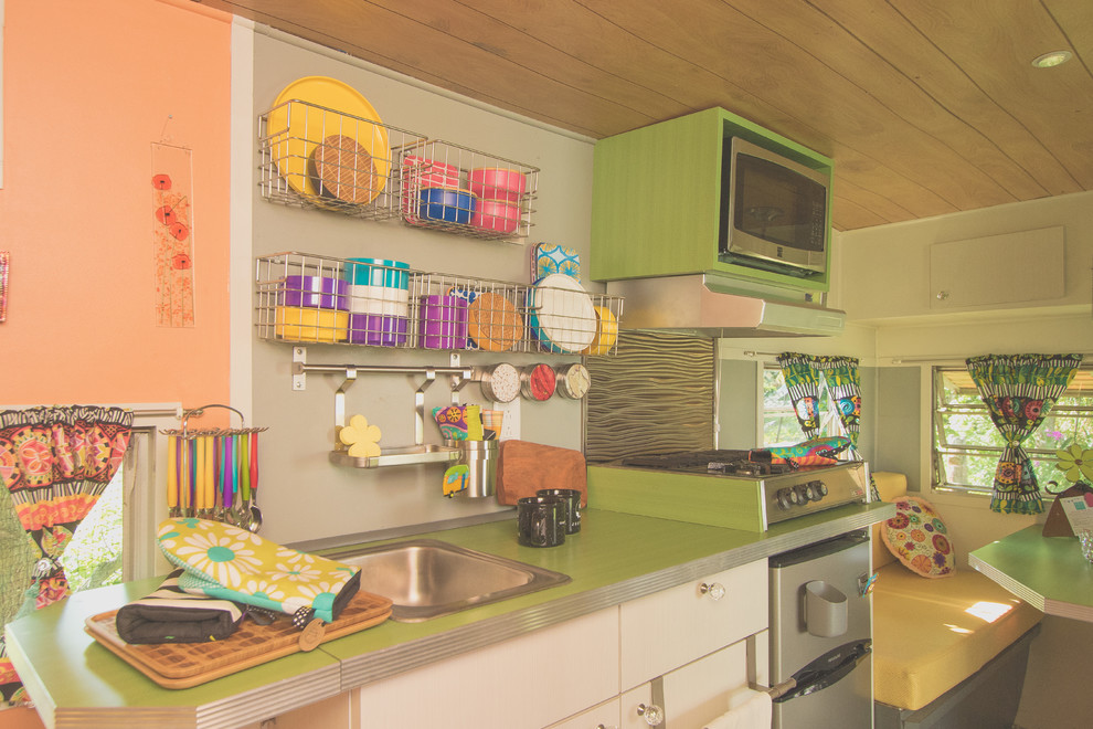Bild på ett litet eklektiskt grön linjärt grönt kök och matrum, med en enkel diskho, släta luckor, vita skåp, laminatbänkskiva, rostfria vitvaror, vinylgolv och grått golv