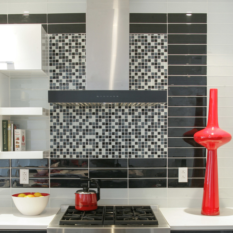 Inspiration for a modern single-wall eat-in kitchen remodel in Montreal with an undermount sink, flat-panel cabinets, black cabinets, quartz countertops, white backsplash, glass tile backsplash and stainless steel appliances