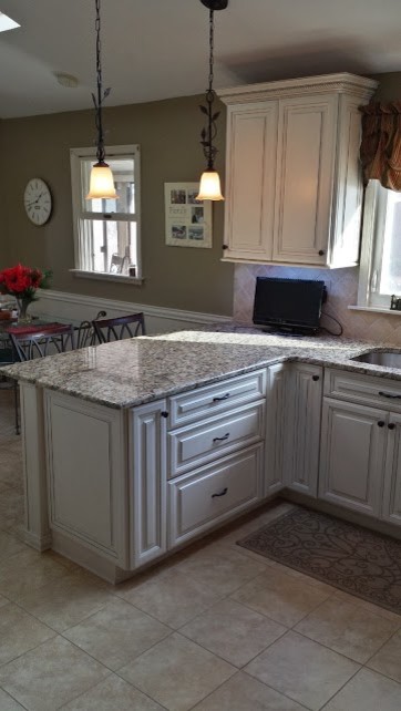 Foto di una cucina chic con lavello sottopiano, ante con riquadro incassato, ante bianche, top in granito e paraspruzzi beige