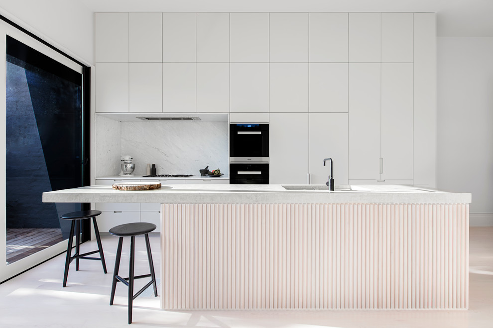 Стильный дизайн: кухня в скандинавском стиле с врезной мойкой, белыми фасадами, столешницей из бетона, белым фартуком, фартуком из каменной плиты, черной техникой, светлым паркетным полом и островом - последний тренд