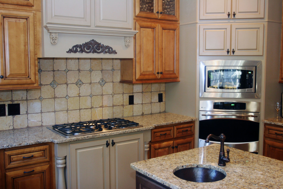 Inredning av ett medelhavsstil kök, med en undermonterad diskho, granitbänkskiva, rostfria vitvaror och en köksö