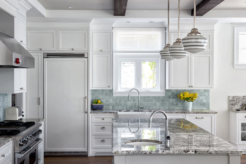 Inspiration for a traditional kitchen in Vancouver with a belfast sink, shaker cabinets, white cabinets, green splashback, metro tiled splashback, integrated appliances, dark hardwood flooring and an island.