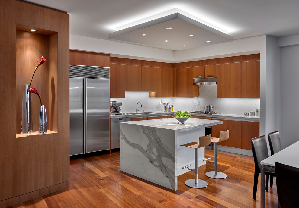 Eat-in kitchen - contemporary l-shaped medium tone wood floor and brown floor eat-in kitchen idea in Chicago with an undermount sink, flat-panel cabinets, medium tone wood cabinets, white backsplash, stone slab backsplash, stainless steel appliances, an island and white countertops