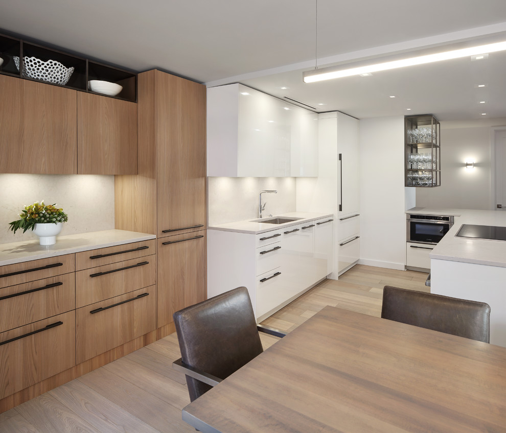 Kleine Moderne Küche mit flächenbündigen Schrankfronten, Elektrogeräten mit Frontblende und Kücheninsel in Chicago