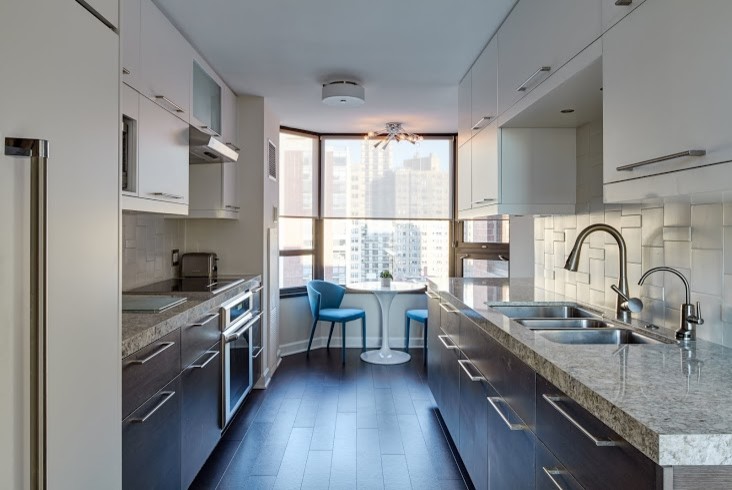 This is an example of a medium sized contemporary galley kitchen/diner in Chicago with a triple-bowl sink, flat-panel cabinets, dark wood cabinets, granite worktops, white splashback, porcelain splashback, dark hardwood flooring, no island and brown floors.