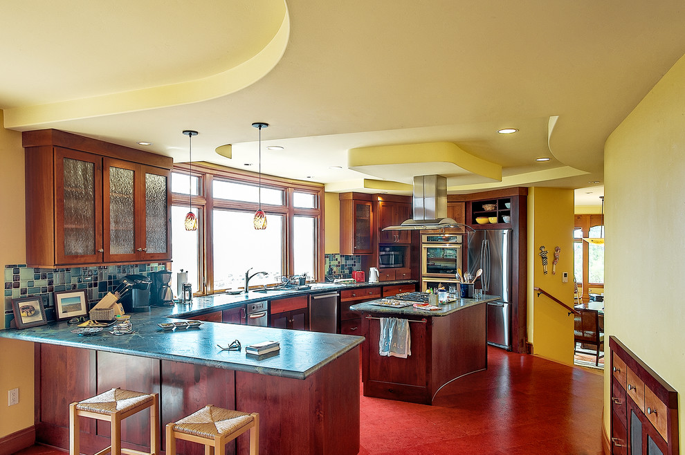 Bild på ett mellanstort eklektiskt kök, med en dubbel diskho, skåp i mörkt trä, blått stänkskydd, stänkskydd i glaskakel, rostfria vitvaror, en köksö, luckor med infälld panel, marmorbänkskiva, linoleumgolv och rött golv