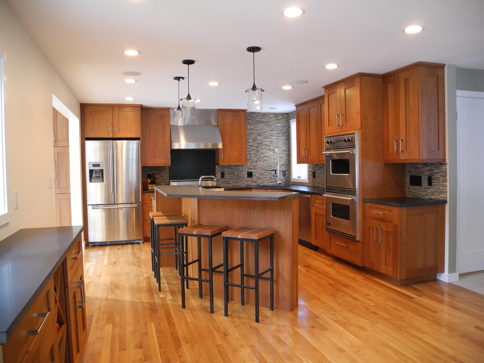 Bild på ett mellanstort vintage kök, med en undermonterad diskho, skåp i shakerstil, skåp i mellenmörkt trä, bänkskiva i betong, grått stänkskydd, stänkskydd i stenkakel, rostfria vitvaror, mellanmörkt trägolv, en köksö och brunt golv