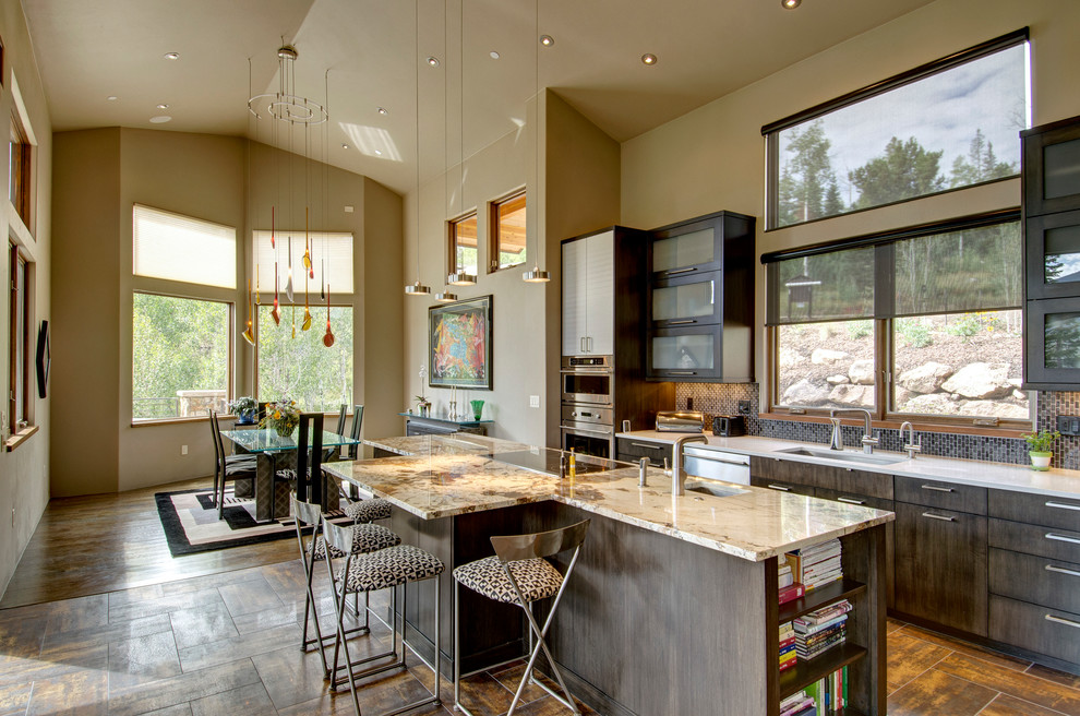 Inspiration for a contemporary galley eat-in kitchen remodel in Denver with an undermount sink, glass-front cabinets, dark wood cabinets, brown backsplash and stainless steel appliances