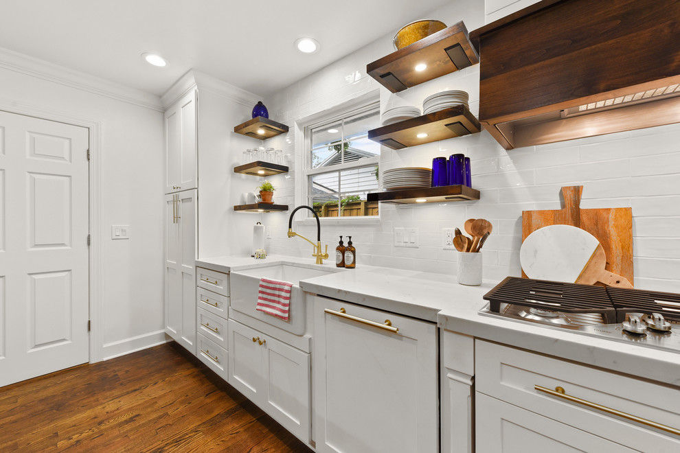Exempel på ett mellanstort modernt vit vitt kök, med en rustik diskho, skåp i shakerstil, vita skåp, bänkskiva i kvarts, vitt stänkskydd, stänkskydd i tunnelbanekakel, rostfria vitvaror, mellanmörkt trägolv, en köksö och brunt golv