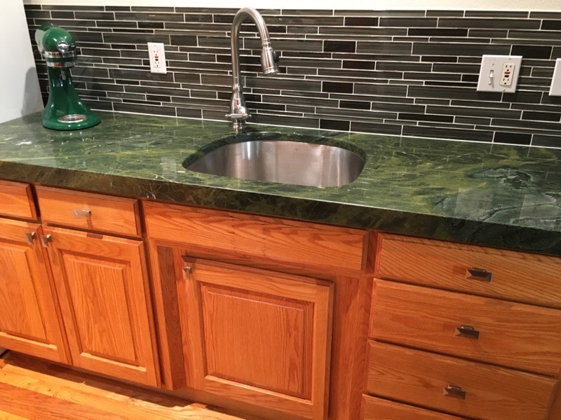 Exemple d'une cuisine en bois brun avec un évier encastré, un plan de travail en granite, une crédence multicolore, une crédence en carreau de verre, îlot et un plan de travail vert.