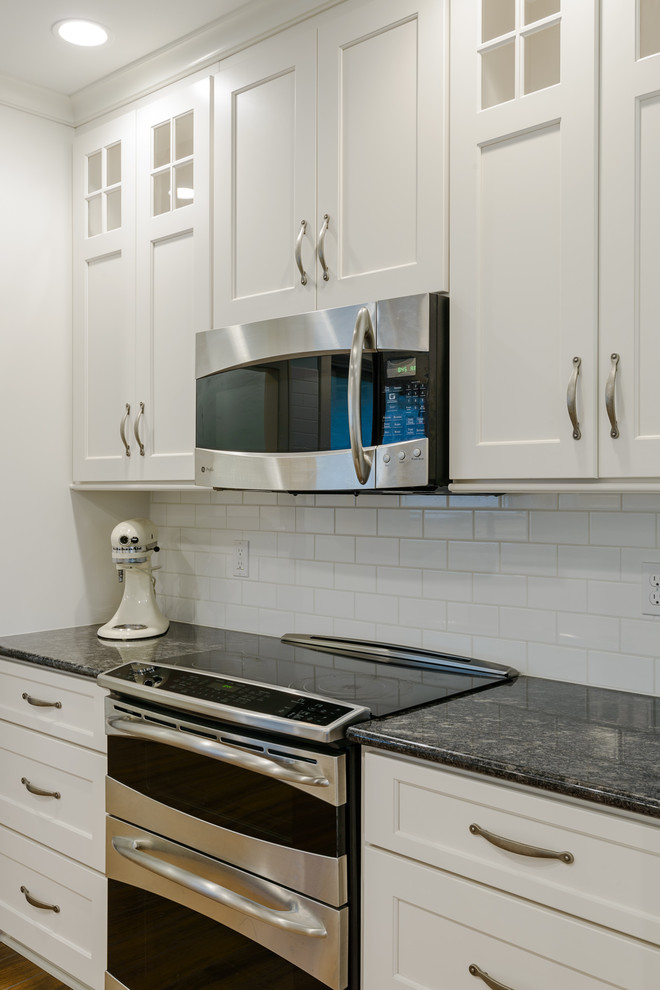 Minimalist kitchen photo in Other with white cabinets and granite countertops