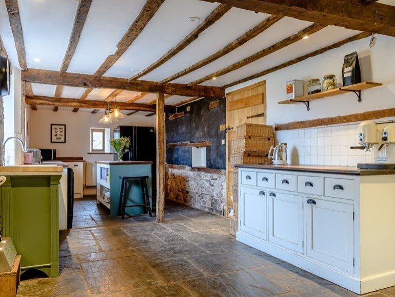 Foto di un cucina con isola centrale country chiuso con lavello stile country e travi a vista