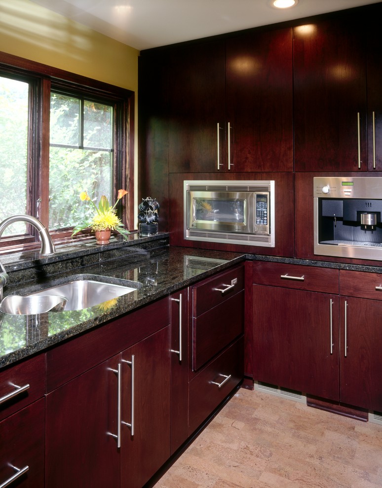 Inspiration for a traditional u-shaped kitchen in Minneapolis with a submerged sink, flat-panel cabinets, dark wood cabinets, granite worktops, stainless steel appliances, an island and cork flooring.
