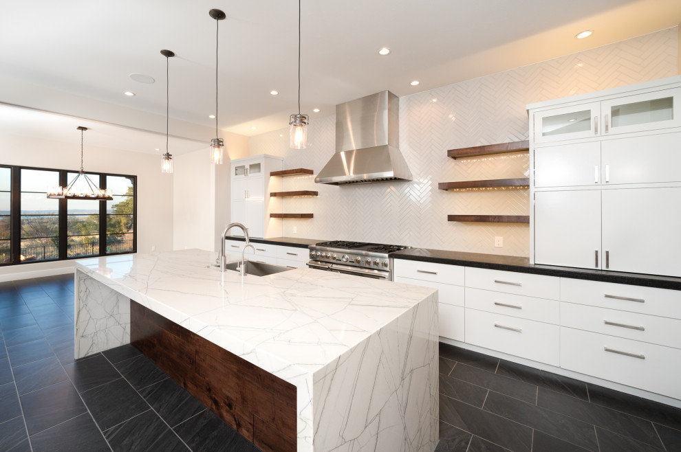 Inspiration for a modern single-wall kitchen/diner in Austin with a belfast sink, flat-panel cabinets, white cabinets, marble worktops, white splashback, ceramic splashback, stainless steel appliances, porcelain flooring, an island, grey floors and white worktops.