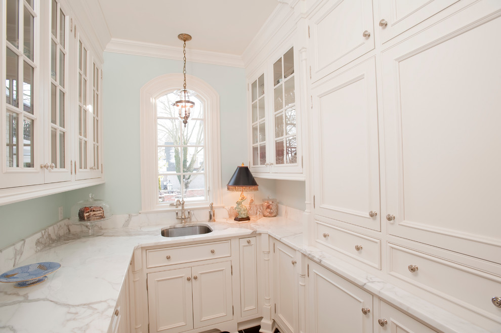 Exemple d'une petite arrière-cuisine parallèle chic avec un évier encastré, des portes de placard blanches, plan de travail en marbre, un sol en carrelage de céramique, un sol noir et un plan de travail blanc.