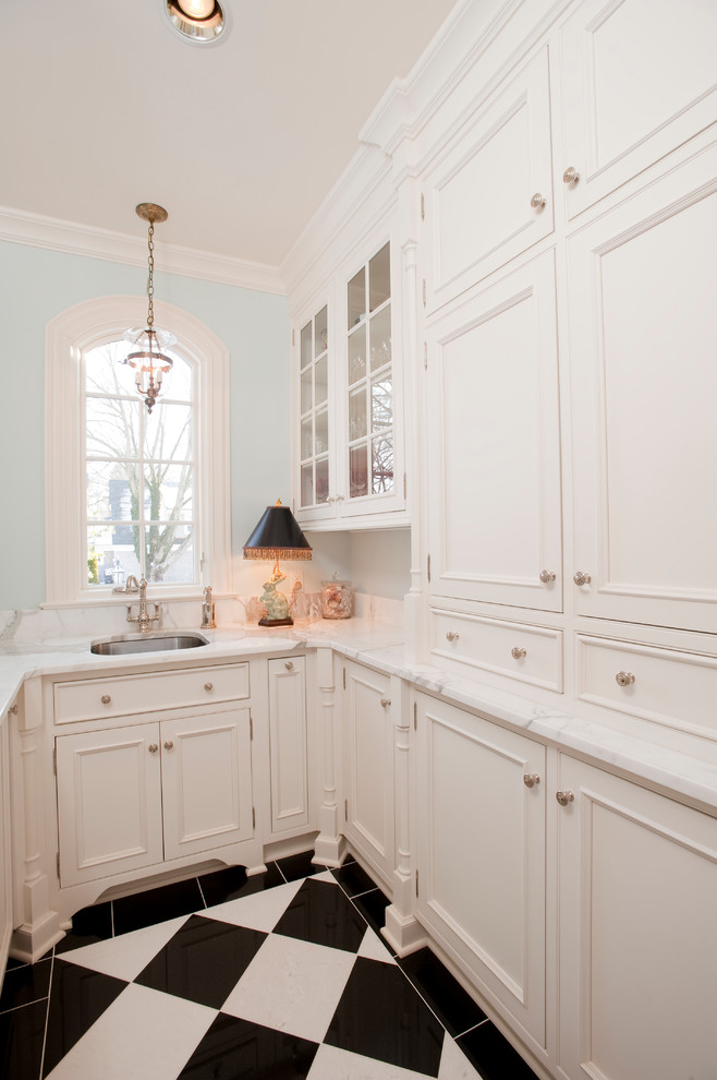 This is an example of a small traditional galley kitchen pantry in Indianapolis with a submerged sink, white cabinets, marble worktops, ceramic flooring, black floors and white worktops.