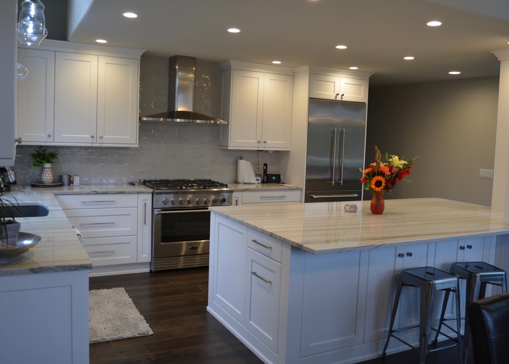 Inspiration for a large classic l-shaped kitchen in Seattle with a submerged sink, shaker cabinets, white cabinets, granite worktops, grey splashback, ceramic splashback, stainless steel appliances, dark hardwood flooring, brown floors and grey worktops.