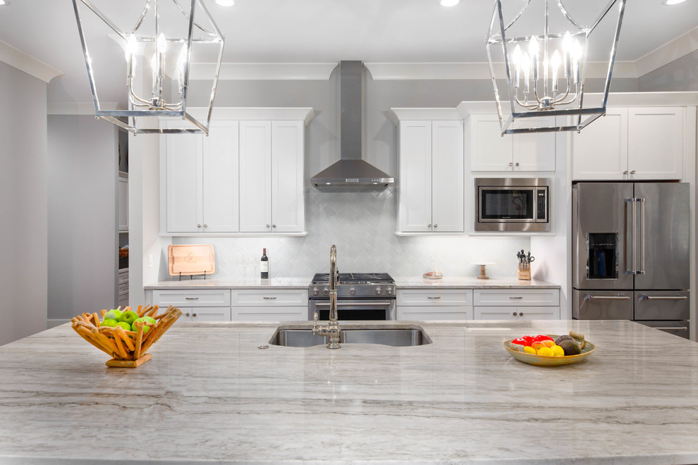 Modern inredning av ett mycket stort grå grått kök, med en undermonterad diskho, skåp i shakerstil, vita skåp, bänkskiva i kvartsit, grått stänkskydd, stänkskydd i keramik, rostfria vitvaror, klinkergolv i keramik, en köksö och brunt golv