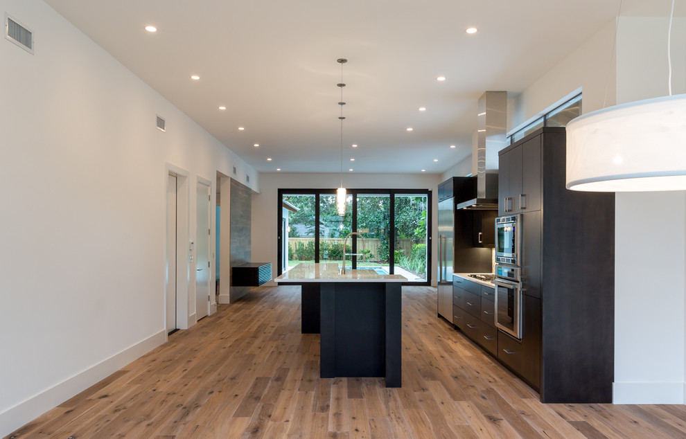 Inspiration for a mid-sized modern single-wall medium tone wood floor open concept kitchen remodel in Austin with an undermount sink, flat-panel cabinets, dark wood cabinets, quartz countertops, beige backsplash, ceramic backsplash, stainless steel appliances and an island
