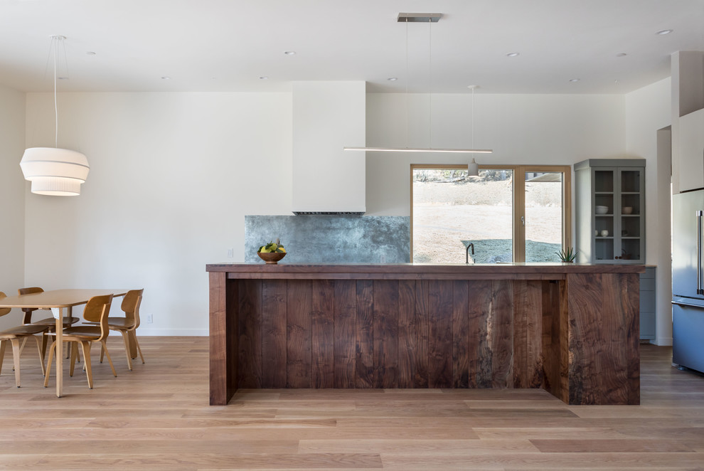 Zweizeilige, Mittelgroße Moderne Wohnküche mit flächenbündigen Schrankfronten, hellbraunen Holzschränken, Küchenrückwand in Grau und Kücheninsel in Sacramento