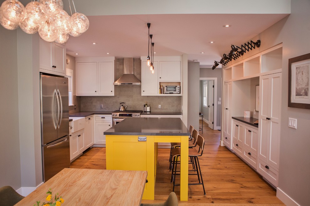 Large cottage u-shaped medium tone wood floor and brown floor eat-in kitchen photo in San Francisco with a farmhouse sink, shaker cabinets, white cabinets, gray backsplash, stainless steel appliances and an island