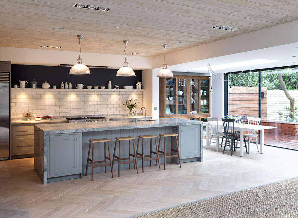 Exempel på ett stort modernt grå linjärt grått kök med öppen planlösning, med en undermonterad diskho, marmorbänkskiva, vitt stänkskydd, stänkskydd i cementkakel, ljust trägolv, en köksö och beiget golv